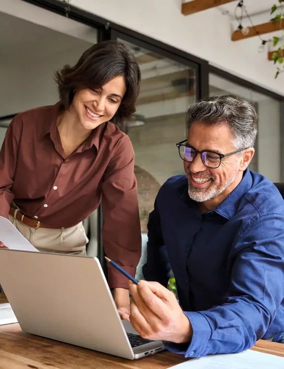 two people looking over information on laptop